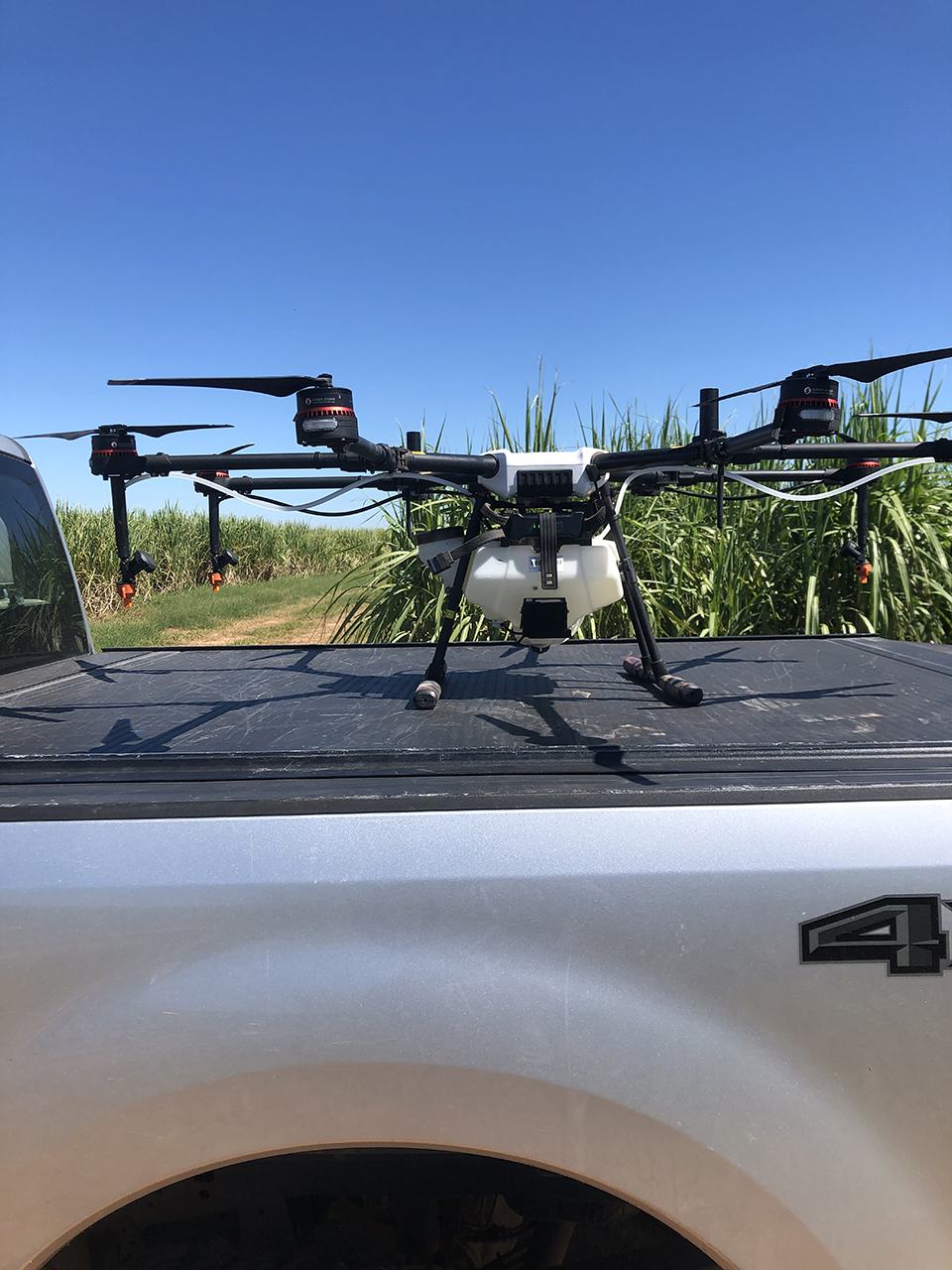 Drone resting on the back of a pickup truck.